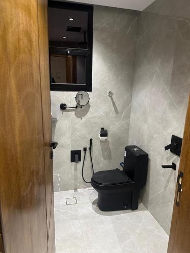 a bathroom with a black toilet and a shower at مسكن ترف للشقق الفندقية in Al Majma'ah