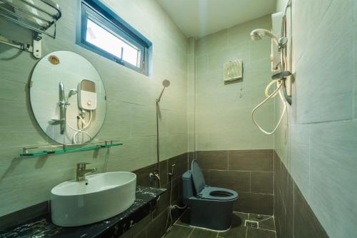 a bathroom with a sink and a toilet and a mirror at Thiên Vy Homestay in Phú Quốc