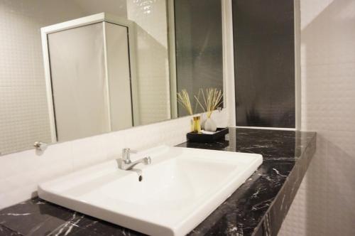 a bathroom with a white sink and a mirror at Makathanee Resort in Ko Mak