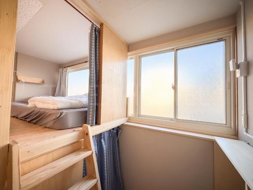 a tiny house with a bed and a window at Fukuoka Tabiji Hostel 福岡旅路ゲストハウス in Fukuoka