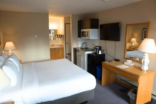 una camera da letto con un letto e una scrivania e una cucina di Chalet Inn a Kitimat