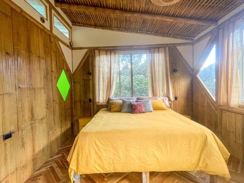 una camera da letto con un letto giallo in una stanza con una finestra di Casa Oak a Tzununá