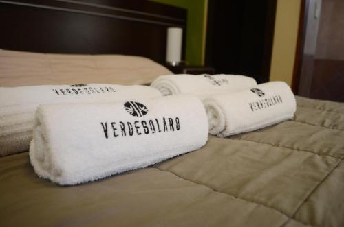 three towels are sitting on top of two beds at Hotel Suite y SPA VerdeSolaro in Villa Elisa