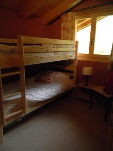 a bedroom with two bunk beds and a window at Chalet Arc-en-Ciel in Nendaz