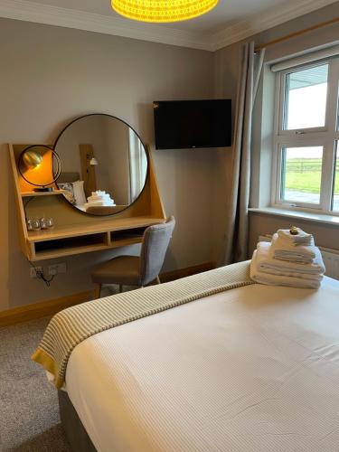 a bedroom with a mirror and a bed and a chair at Ceol na dTonnta in Doolin