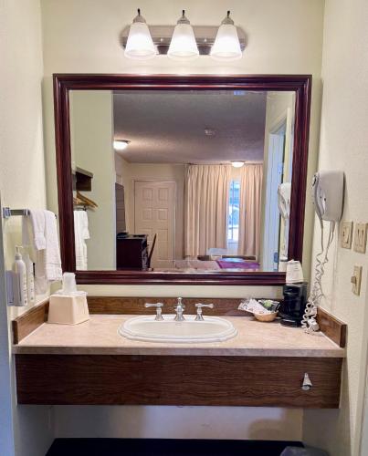 a bathroom with a sink and a large mirror at Thunderbird Motel in Elko