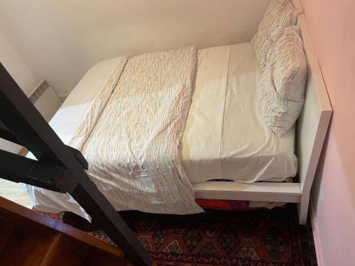 a bed in a small room with a bed frame at T2 accueil proche Paris in Sartrouville