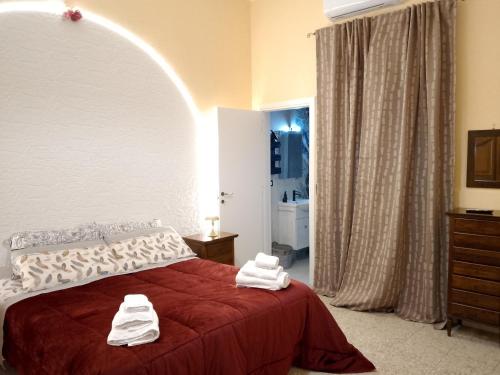 a bedroom with a red bed with towels on it at Bred breakfast D&D in Augusta