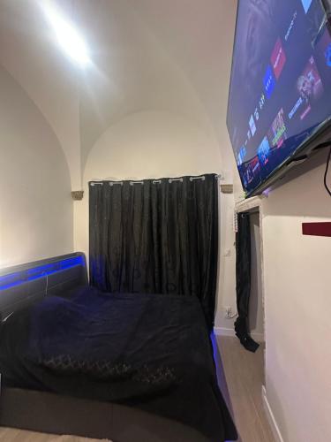 a bedroom with a bed and a large screen at Magnifique appartement neuf Bellecour in Lyon