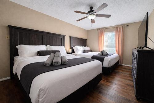 a bedroom with two beds and a ceiling fan at Amazing Bay Villa Near NASA with Pool & Pool Table in Houston