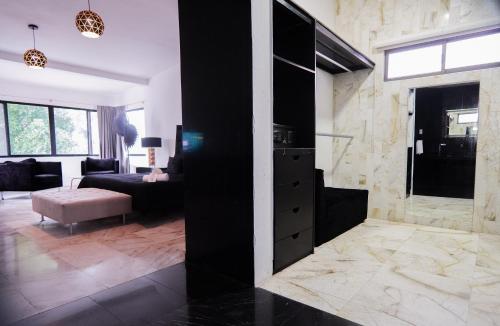 a living room with a black cabinet and a couch at Villa Maraf - Adults Only Boutique Hotel in Cancún