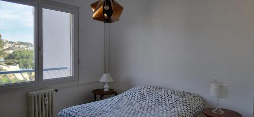 a bedroom with a bed and a large window at Appartement Le Cap in Toulon