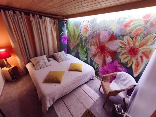 a bedroom with a bed and a flower mural at Spa et Sauna Le Roosevelt in Château-Thierry