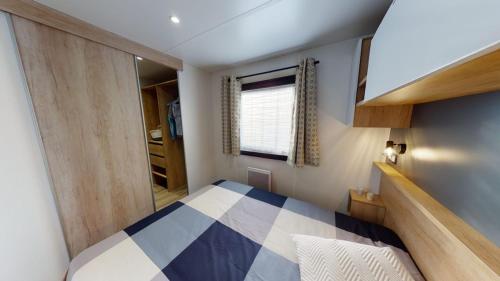 a small bedroom with a bed and a window at Vacances la Palmyre in Les Mathes