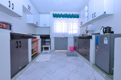 a large kitchen with blue cabinets and appliances at Lola Homes Thika in Thika