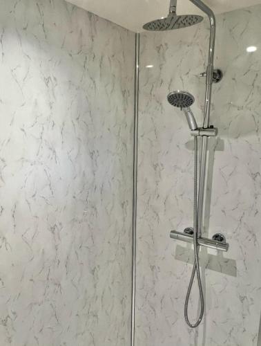 a shower with a shower head in a bathroom at Ballyaghran Stay in Portstewart
