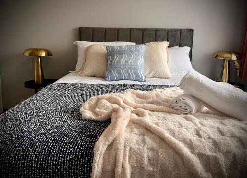 a bed with a blanket and pillows on it at Howrah Apartment in Howrah