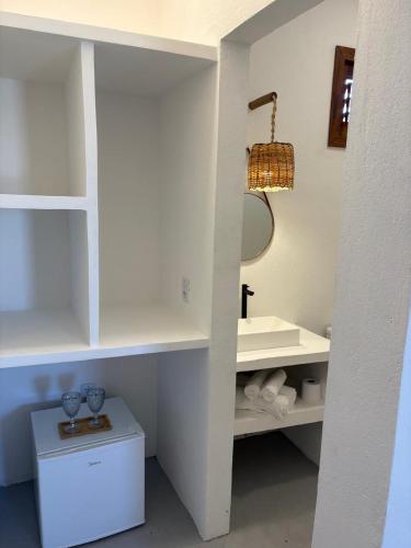 a white bathroom with a sink and a mirror at Amagali Beach Club in Galinhos