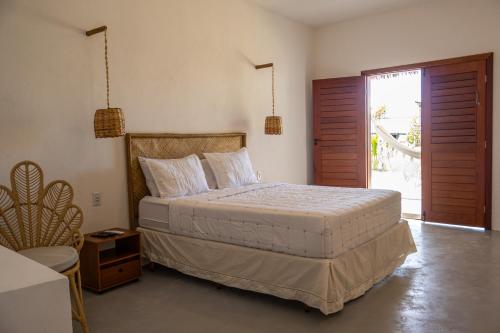 a bedroom with a bed and a door to a patio at Amagali Beach Club in Galinhos