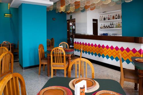 a restaurant with blue walls and wooden tables and chairs at Hotel Escala Siglo XXI in Mexico City