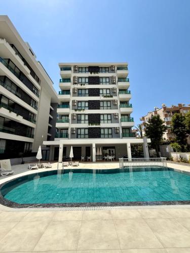 a swimming pool in front of a large building at SA Apartments! 150m to the Cleopatra Beach in Alanya