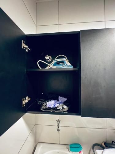 a bathroom with a sink and a black wall at Residencial Mª Do Bonfim - 5km Aeroporto JK in Brasília