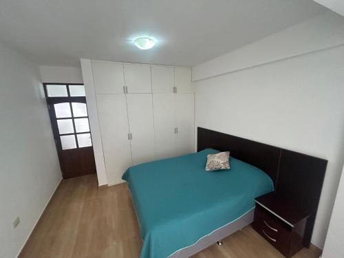 a small bedroom with a blue bed and white cabinets at Edificio Subieta in Sucre