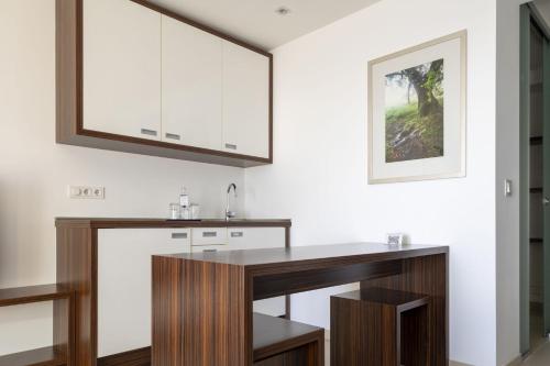 a kitchen with white walls and wooden cabinets at Strandhotel Dranske in Dranske