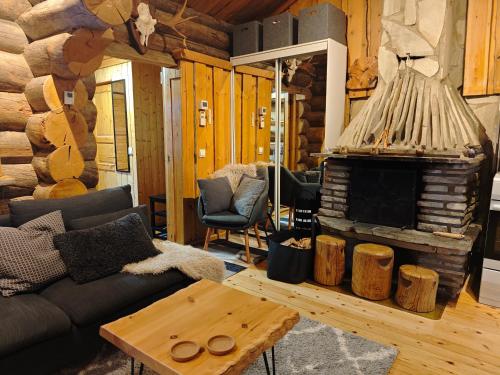 a living room with a couch and a fireplace at Holiday Hopsukka in Luosto