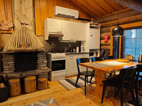 a kitchen with a table and a fireplace in a room at Holiday Hopsukka in Luosto