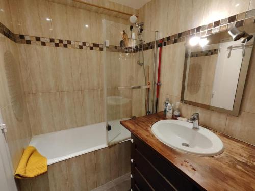 a bathroom with a sink and a shower and a tub at Appartement spacieux in Argenteuil