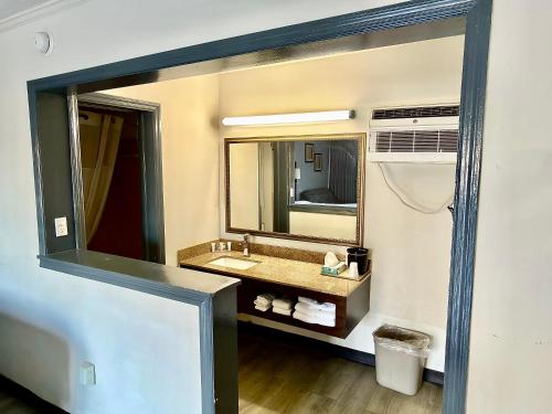 a bathroom with a sink and a mirror at Budget Inn Conway in Conway