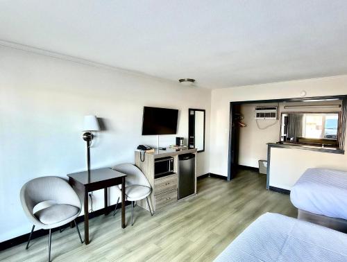 a room with a bed and a desk with a television at Budget Inn Conway in Conway