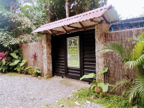 a building with a door with a sign on it at Casajungla Hostel in Jacó
