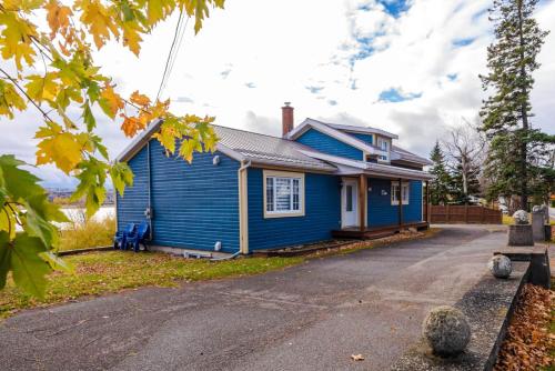 a blue house with a road in front of it at Hôtel à la maison - La Bleue Maritime in Rivière-du-Loup