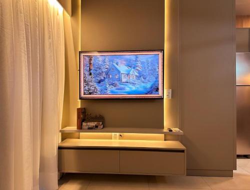 a bathroom with a painting of a house on the wall at Studio Prime Ribeirão Apogeo in Ribeirão Preto