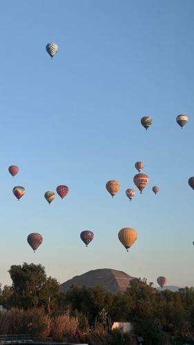 eine Gruppe Heißluftballons am Himmel in der Unterkunft Teoti Querido in San Juan Teotihuacán