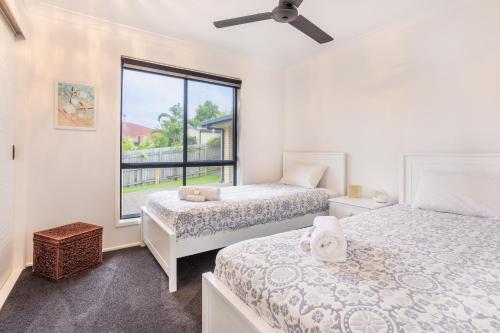 two beds in a room with a window at The Hideaway in Yeppoon