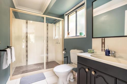 a bathroom with a shower and a toilet and a sink at The Hideaway in Yeppoon