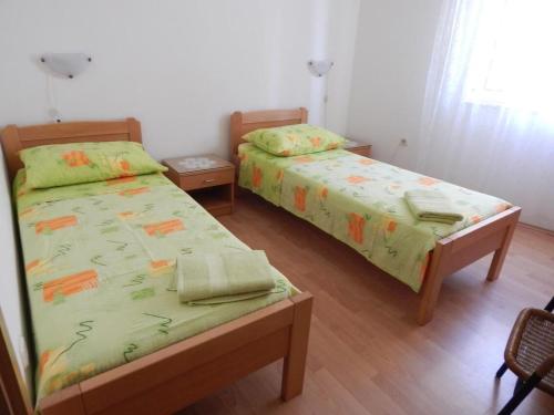 two beds sitting next to each other in a room at Apartments Zoki in Vis