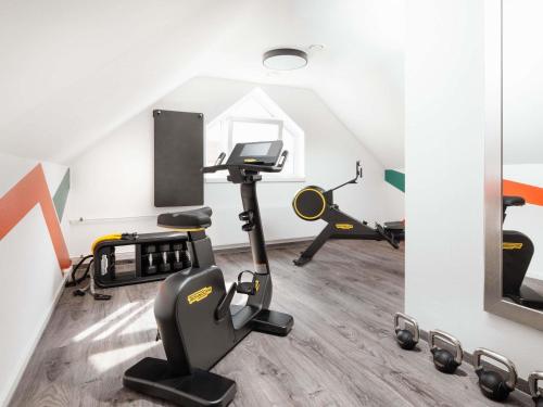 a gym with exercise equipment in a attic at ibis Styles Neckarsulm in Neckarsulm