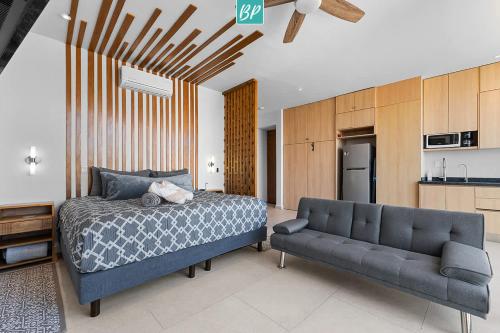 a bedroom with a bed and a couch at Makare Bucerias - Rooftop Pool and Steps to Beach in Bucerías
