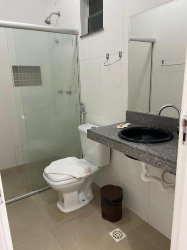 a bathroom with a toilet and a sink and a shower at Hotel e Restaurante Star New in Carmópolis