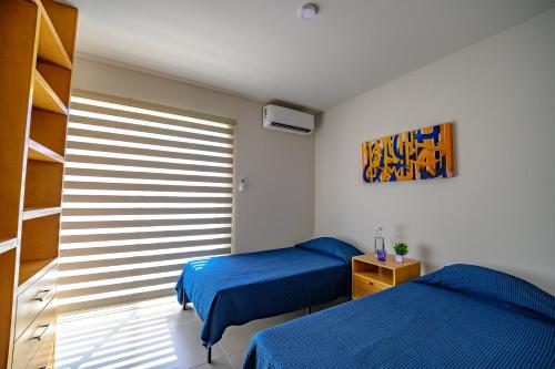 a bedroom with two beds and a window at Departamento La Paloma in Cabo San Lucas