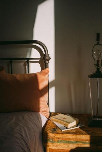 a bed with a book on a table with a lamp at Object Hotel 2BR Room 2B in Bisbee