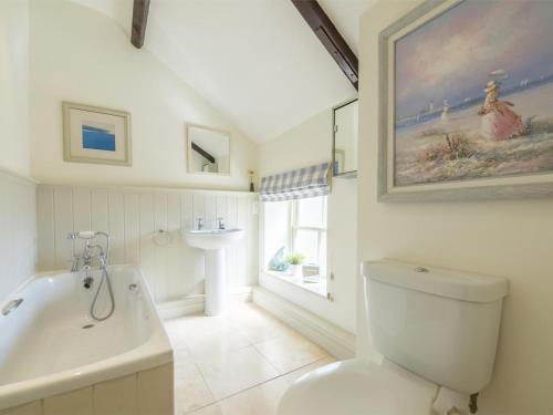 a bathroom with a tub and a toilet and a sink at 2 Bed in Dersingham oc-kt082 in Dersingham