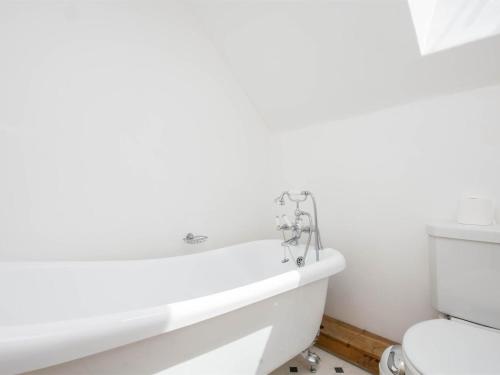 a white bathroom with a tub and a toilet at 3 Bed in Wareham oc-dc023 in West Lulworth