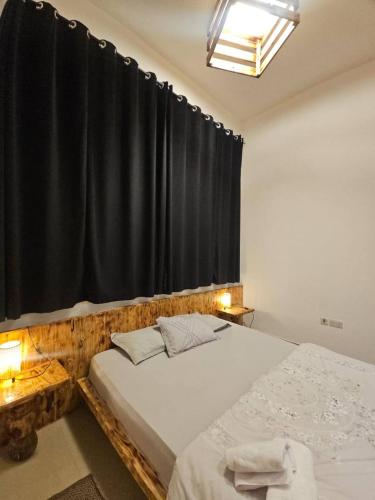 una camera da letto con due letti e una tenda nera di Black Moon Studio jimi a Al Ain