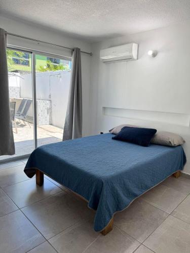 a bedroom with a bed with a blue blanket at Casa Toreo in Mazatlán