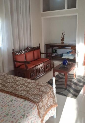 a room with a bed and a chair and a table at Estância Jockey Clube in Sao Jose do Rio Preto
